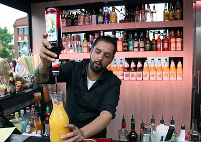 Barkeeper wie er gerade einen Sex on the Beach herstellt.